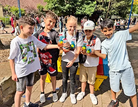 Fünf Kinder stehen zusammen und freuen sich über ein Slush-Eis